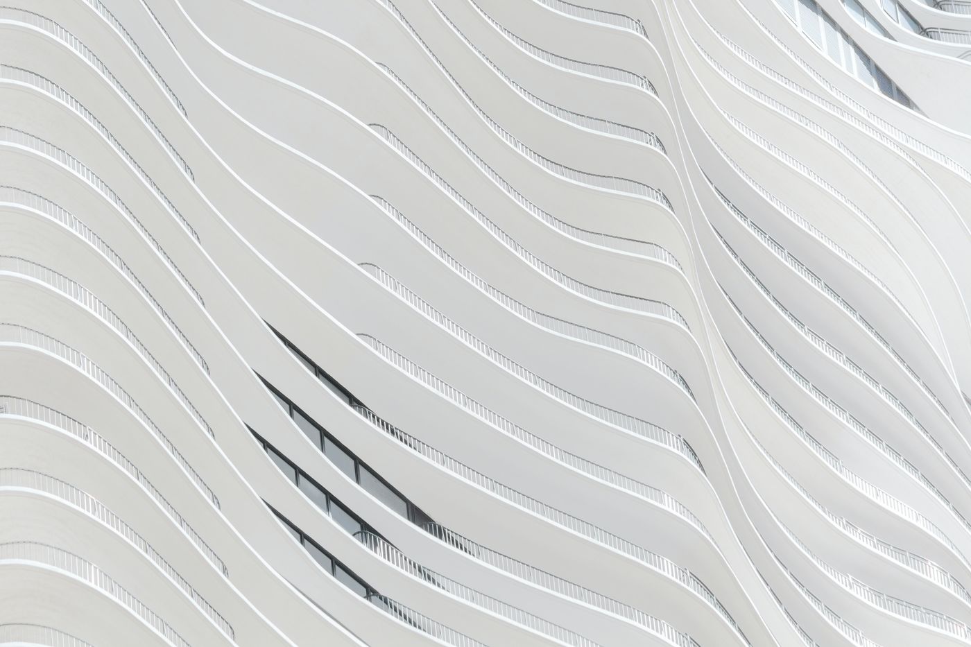 Fachada ondulada de arquitectura moderna en blanco, representando visión global e innovación